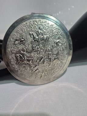 Vintage Tussy silver-tone compact with embossed Persian hunting scene.